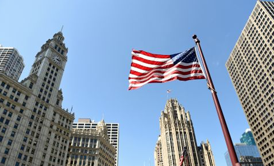 American flag flying among city buildings